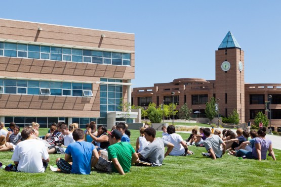 Freshmen Seminar students sitting on the West Lawn with Osborne Center and El Pomar Center visible behind them