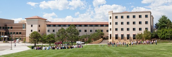 Panoramic image of students on the West Lawn with Summit Village behind them (Summit and Vail houses)