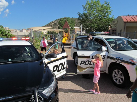 UCCS police officers demonstrate lights and sirens in a police car.