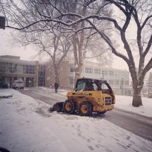 A Facilities Services plow clears the walkway in front of main hall after a snow storm in April 2013