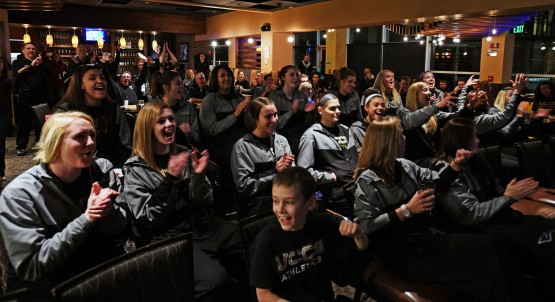 The UCCS women's basketball celebrate a trip to the NCAA Division 2 tournament and a number 2 seed in their bracket during a watch party at Clydes March 8. (JERILEE BENNETT/THE GAZETTE)