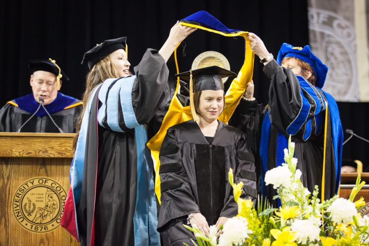 Carrie Arnold, assistant director, Freshman Seminar Program and Honors Program, receives her hood during May 13 graduation ceremonies.