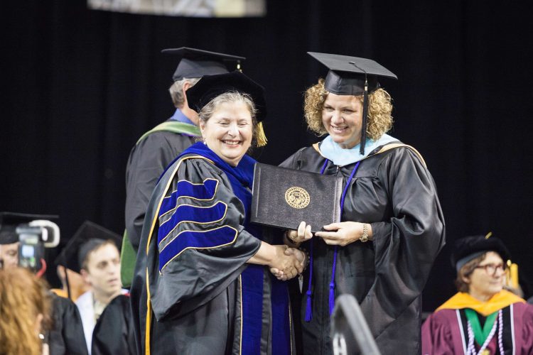 Interim Provost Terry Schwartz presents Mollie Sutherland, right, with her degree at May 13 ceremonies.