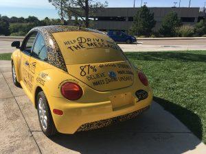 A second-hand VW bug serves as a rolling billboard.