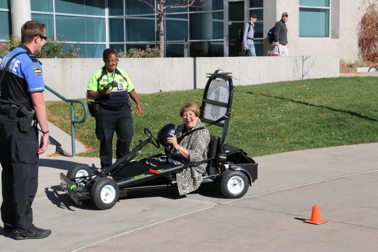 Chancellor Pam Shockley-Zalabak prepares to give the simulated impaired driving vehicle a try.