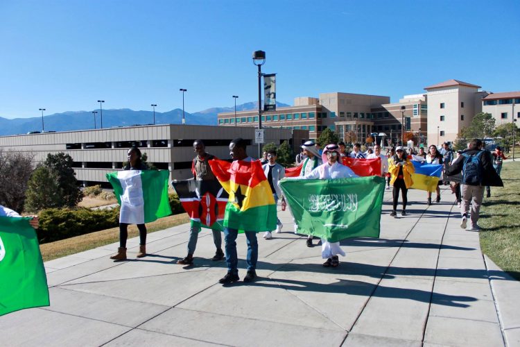 International students walk with flags at UCCS