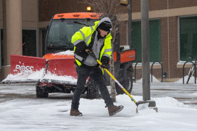 Facilities Services crew member shovels snow Feb. 18.