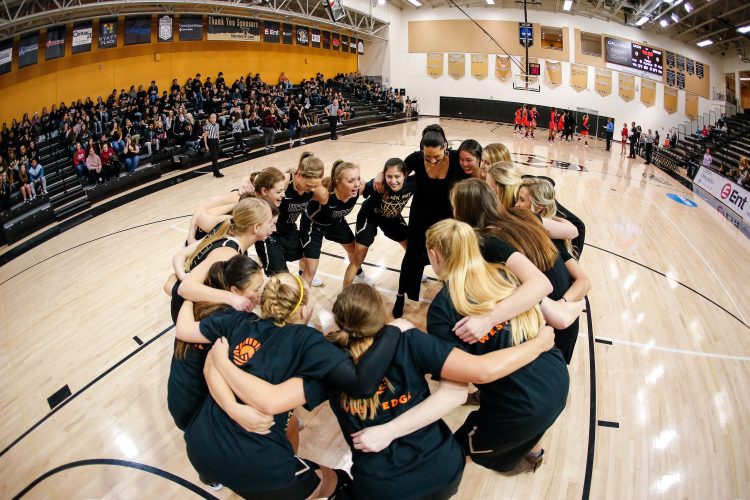 Women's team huddle on Blackout Night, Feb. 8.