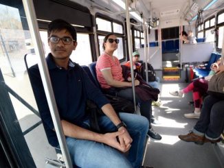 A student rides a bus at CU Boulder