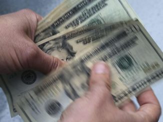 A person sorts through $20 bills.
