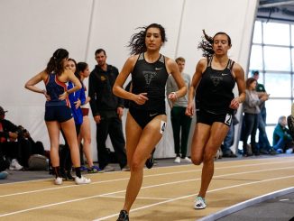 Layla Almasri and Maia Austin run on the track in Mountain Lion Fieldhouse