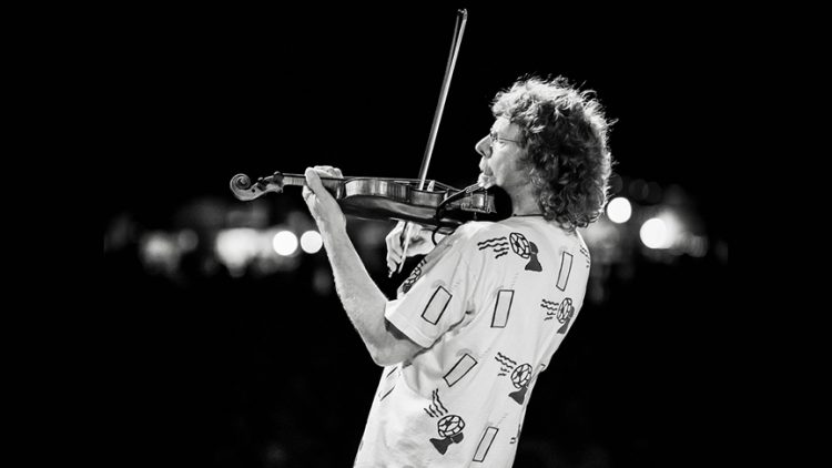 An action photo of Sam Bush playing the violin