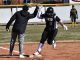 PAyton Romines high-fives Head Coach Rothbauer-Stubbs while rounding third base.