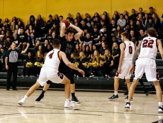 Ed Bourke holds the ball against a defender from Colorado Mesa.