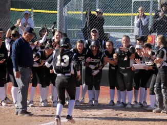 The Mountain Lion team celebrates at home plate as Brianna Santos runs to the plate after a home run.