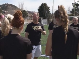 Screenshot of JB Belzer meeting the women's soccer team in a huddle.