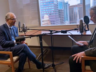 CU President Mark Kennedy speaks into a microphone for a podcast recording.