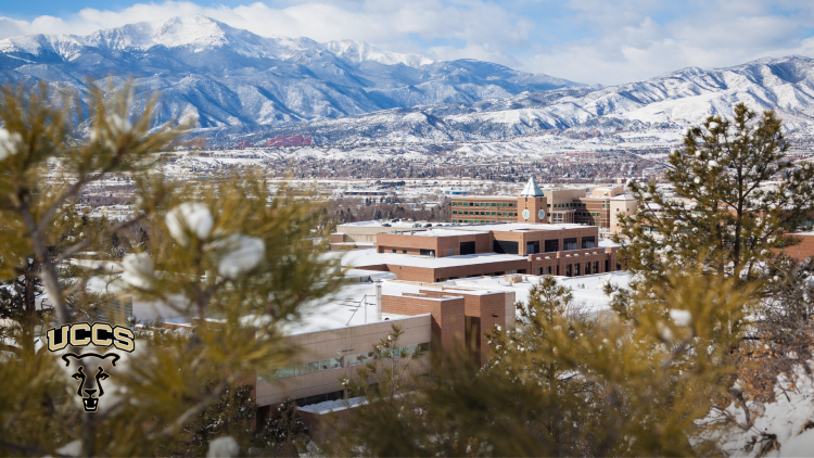 A photo of campus after a snowfall, with Pikes Peak and the Rampart Range in the background