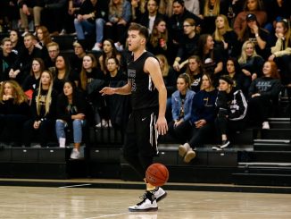 Blend Avdili dribbles the basketball with a crowd in the background