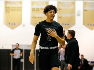 Alijah Comithier taps his chest walking back to the team bench in the Gallogly Events Center
