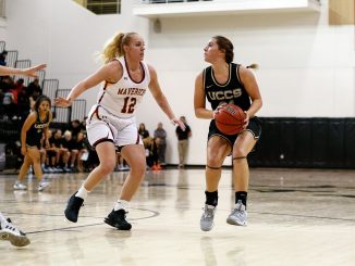 Madi Gaibler prepares to plant to shoot the basketball against a defender in the Gallogly Events Center