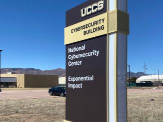 The exterior sign at the UCCS Cybersecurity Building with a blue sky