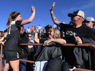 Kaitlin Hinkle gives a fan a high-five after a game at Mountain Lion Stadium