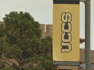A UCCS banner on a lamp post on campus