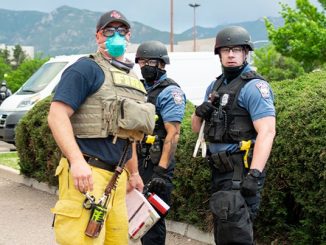 Three officers wearing vests standing outside