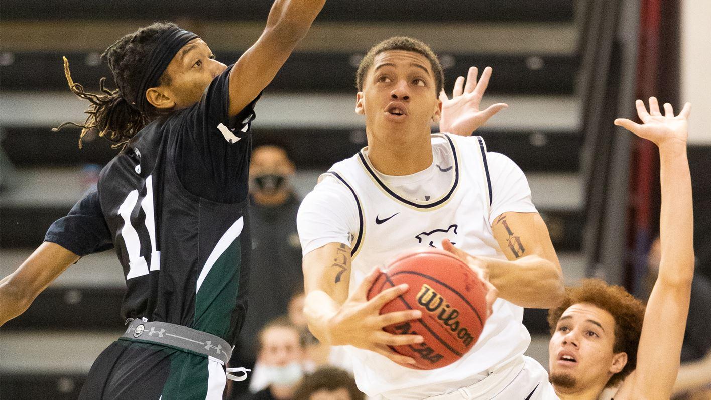 Alijah Comithier shooting an underhanded layup against a defender