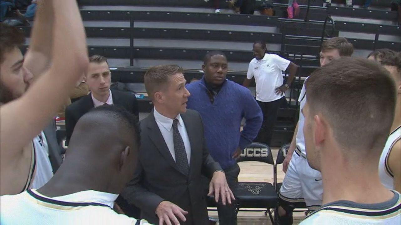 UCCS Head Men's Basketball Coach Jeff Culver in the middle of a team huddle