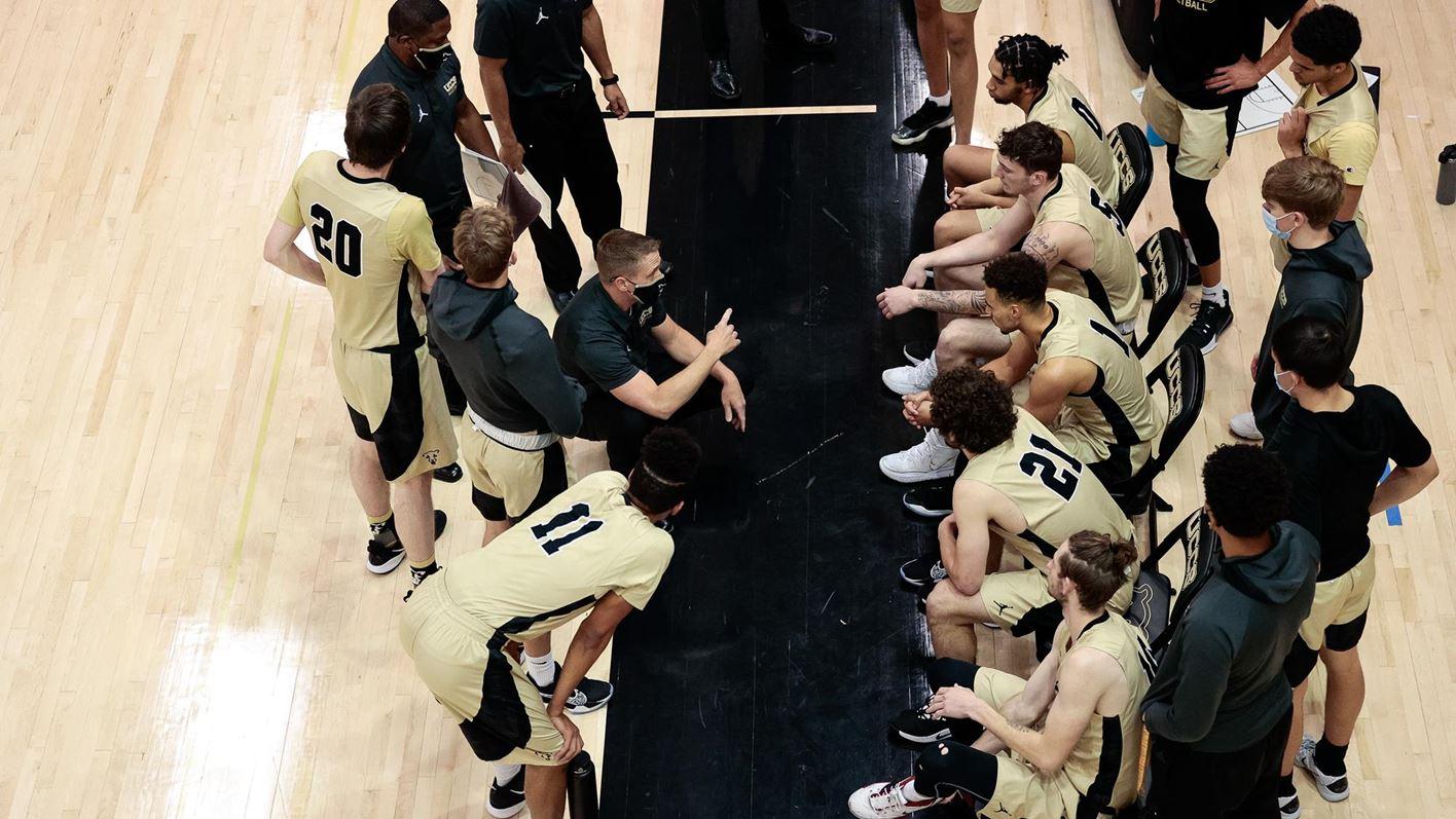 Men's basketball team huddle during a timeout