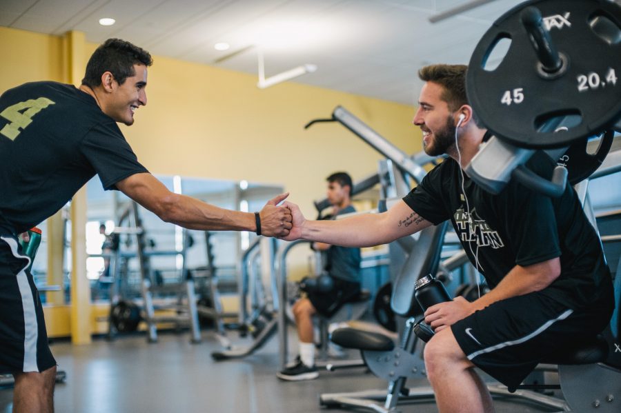Two athletes shake hands at the gym.