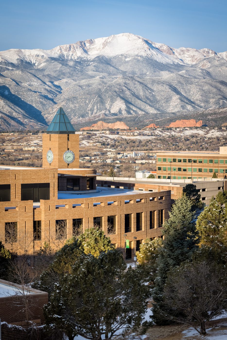 A snow-covered El Pomar Center on the UCCS campus in front of Pikes Peak. Photo by Jeffrey M Foster